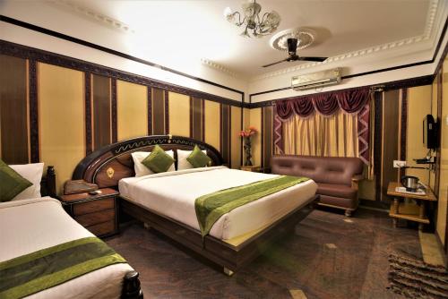 a hotel room with a bed and a chair at Navanidhi Comforts in Bangalore