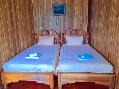 two beds in a room with two blue folders at Tayama Farm Khaoyai in Nakhon Ratchasima