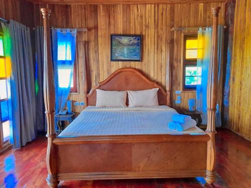 a bed with a wooden frame in a bedroom at Tayama Farm Khaoyai in Nakhon Ratchasima