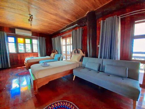a bedroom with two beds and a couch and windows at Tayama Farm Khaoyai in Nakhon Ratchasima