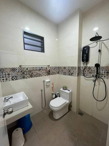 a bathroom with a shower and a toilet and a sink at Hadeerna Homestay - Double storey terrace in Chemor