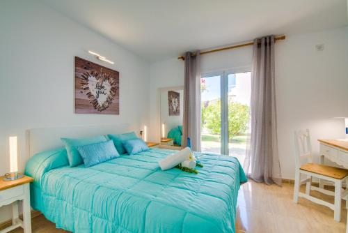 a bedroom with a blue bed and a window at Ideal Property Mallorca - Avus in Alcudia