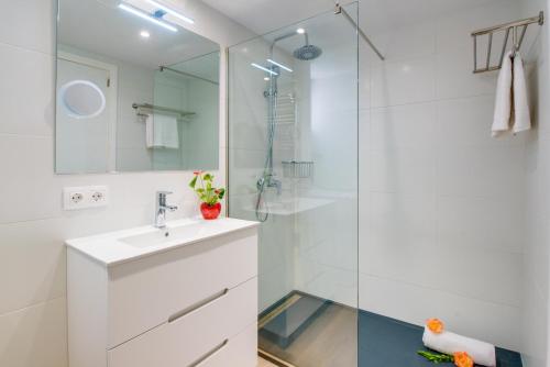 a white bathroom with a sink and a shower at Ideal Property Mallorca - Avus in Alcudia