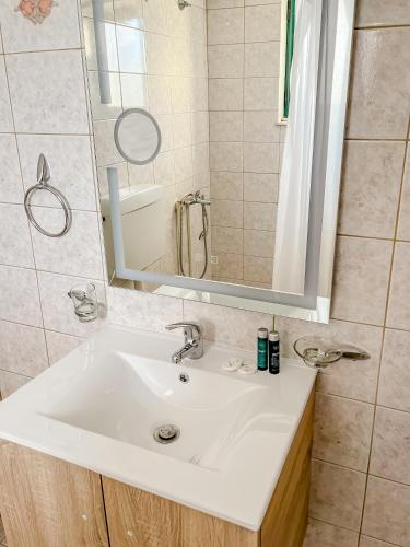 a bathroom with a white sink and a mirror at Island Apartments in Mesolongion
