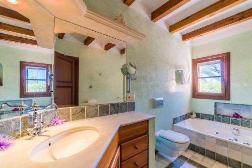 a bathroom with a sink and a tub and a toilet at Ideal Property Mallorca - Axilo - Els Mitjans in Artá