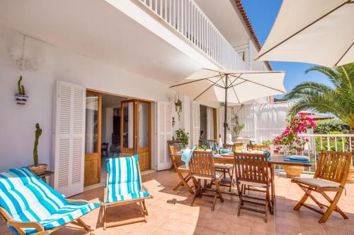 a patio with chairs and a table and an umbrella at Ideal Property Mallorca - Bell Punt in Alcanada