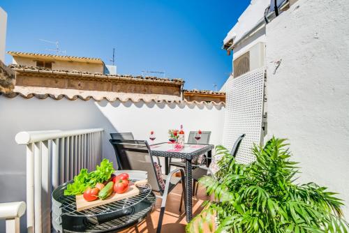 un patio avec une table et des chaises sur un balcon dans l'établissement Ideal Property Mallorca - Ca na Serrieta, à Alcúdia