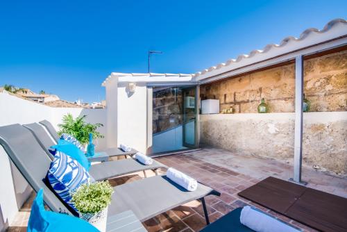un patio avec une table et des chaises sur un balcon dans l'établissement Ideal Property Mallorca - Ca na Serrieta, à Alcúdia
