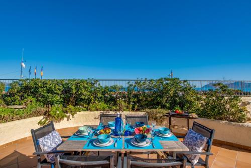 a wooden table with chairs and a meal on it at Ideal Property Mallorca - Ca sa Tati in Son Serra de Marina