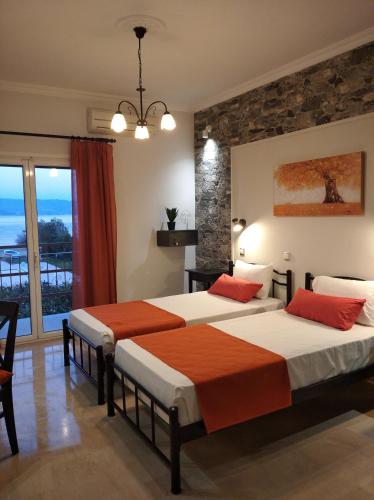 two beds in a room with a balcony at Sofia Beach Apartments in Kavos
