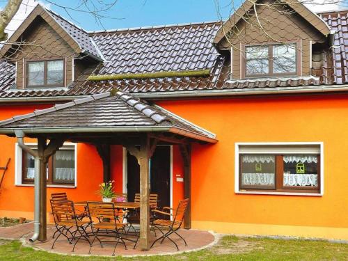 an orange house with a table and chairs in front of it at Ferienhaus Zum Storchennest in Storkow in Storkow