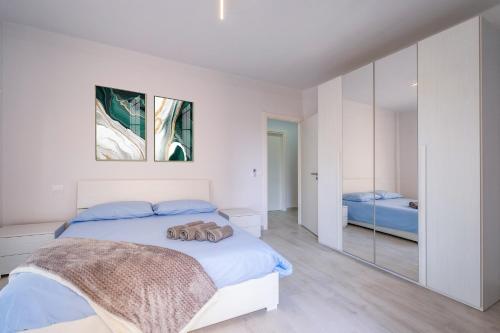 een witte slaapkamer met een bed en een spiegel bij casa la riviera sanremo in Sanremo