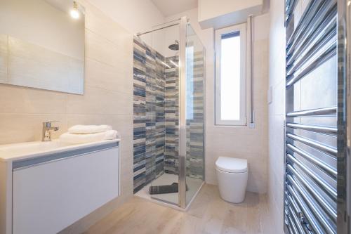 een badkamer met een douche, een toilet en een wastafel bij casa la riviera sanremo in Sanremo