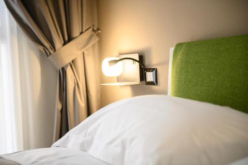 a bedroom with a bed and a lamp and a window at Alma Suites in Naples