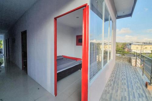 a room with a window with a bed on a balcony at Sky Residence Tomohon Mitra RedDoorz in Tomohon