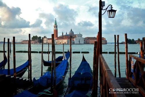 a group of gondolas in the water next to a street light at Ca' Pedrocchi in Venice
