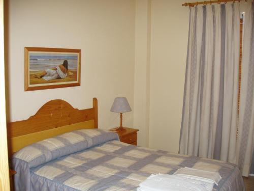a bedroom with a bed and a picture on the wall at Apartamentos Pueblo Salado in Puerto de Mazarrón