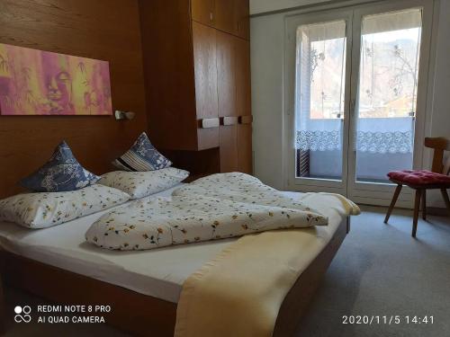 um quarto com uma cama com almofadas e uma janela em Apartement Annabelle em Lana