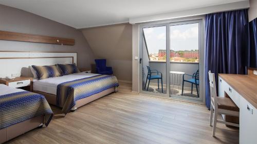 a hotel room with two beds and a balcony at Galeri Resort Hotel - Ultra All Inclusive in Okurcalar