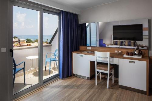 a room with a desk with a view of the ocean at Galeri Resort Hotel - Ultra All Inclusive in Okurcalar