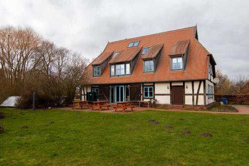 une grande maison avec des tables de pique-nique dans une cour dans l'établissement Eulenhof, 