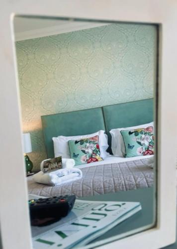 a reflection of a bedroom with a bed with pillows at Beaches Guest House in Southend-on-Sea