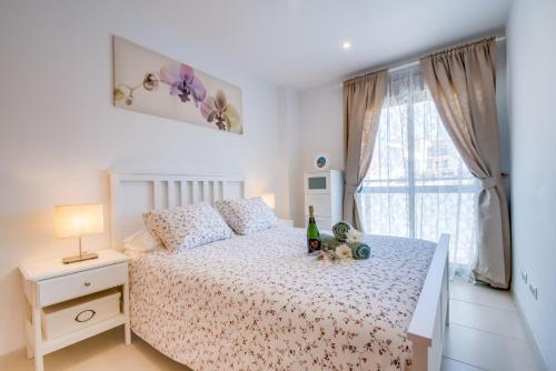una camera da letto con un letto e una bottiglia di vino sopra di Ideal Property Mallorca - Mar Blau a Alcudia