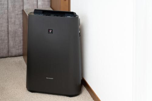 a black refrigerator sitting next to a wall at THE KNOT SAPPORO in Sapporo