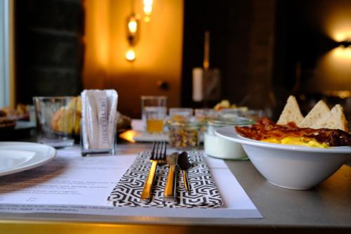 a table with a bowl of food and a plate of food at Settecento Hotel in Presezzo
