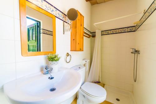 a bathroom with a sink and a toilet and a mirror at Ideal Property Mallorca - Patufa in Alcudia