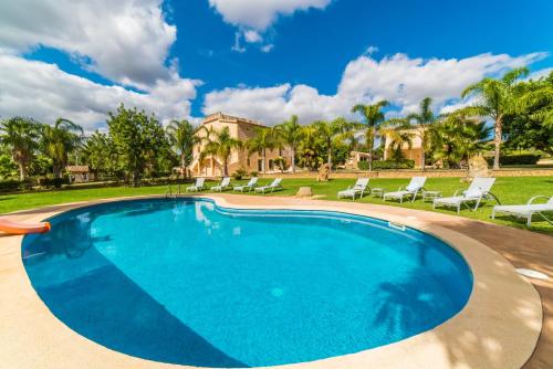 uma piscina com cadeiras e uma casa ao fundo em Ideal Property Mallorca - Perot em Maria de la Salut