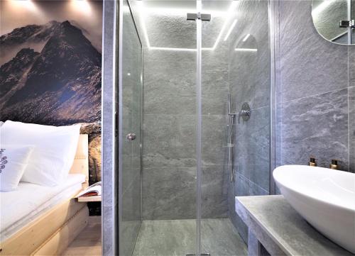 La salle de bains est pourvue d'une douche et d'un lavabo. dans l'établissement Gawra Apartament Studio, à Zakopane