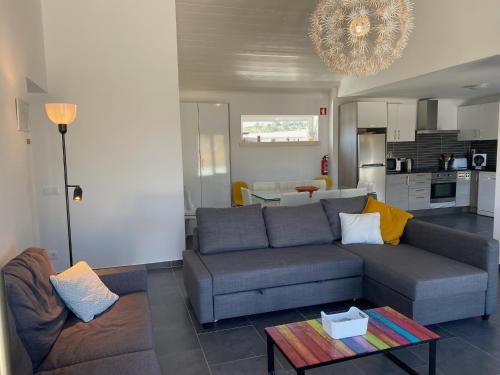 a living room with a couch and a table at VillaVie CostadePrata in Alfeizerão