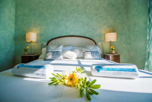 a bed with blue and white sheets and flowers on it at Ideal Property Mallorca - Ram de Mar in Font de Sa Cala