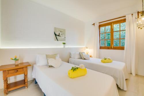 two beds in a room with white walls and windows at Ideal Property Mallorca - Ram de Mar in Font de Sa Cala