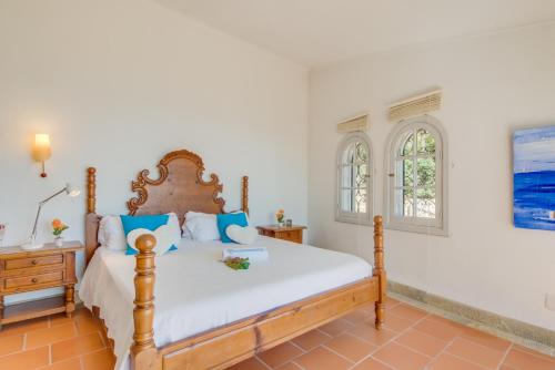 a bedroom with a large bed with blue pillows at Ideal Property Mallorca - Ram de Mar in Font de Sa Cala