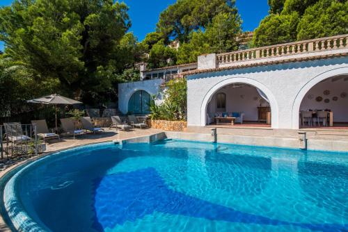 an outdoor swimming pool with blue water in a house at Ideal Property Mallorca - Ram de Mar in Font de Sa Cala