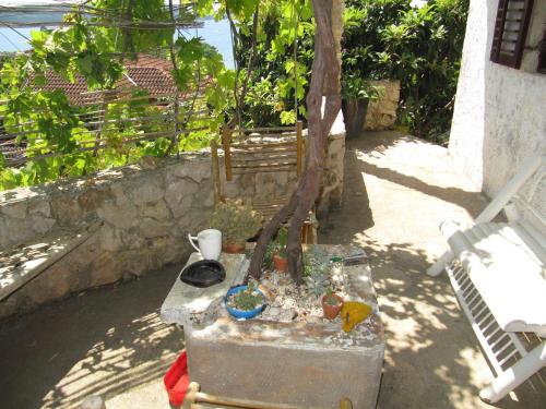 a garden with a table with a tree in it at ApartMarin in Trogir