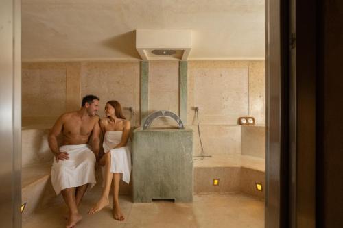 Ein Mann und eine Frau stehen in einer Badewanne in der Unterkunft Hotel Caesius Thermae & Spa Resort in Bardolino