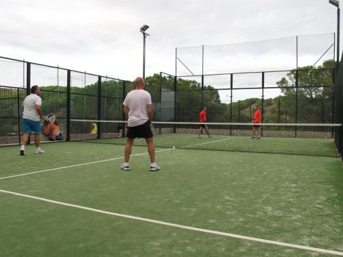 a man standing on top of a tennis court holding a racquet at Camping Roca Grossa in Calella
