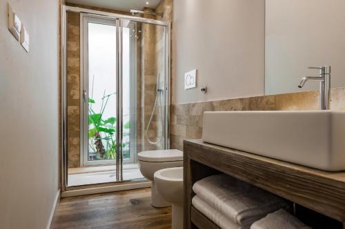 un bagno con lavandino, water e finestra di Ferrini Home - Piazza Trento a Catania