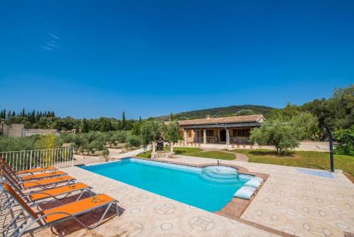 a swimming pool with chairs and a house at Ideal Property Mallorca - Ses Comes in Selva