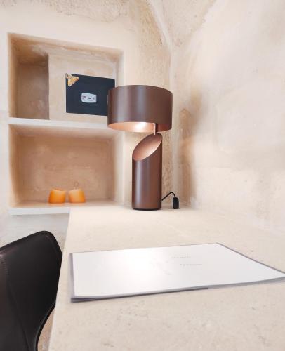 a lamp sitting on a desk with a book at Residence Masseria Santa Lucia in Matera