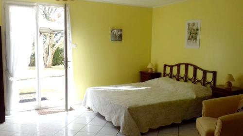 a bedroom with a bed and a sliding glass door at Studio charmant à Sarlat-la-Canéda avec terrasse in Sarlat-la-Canéda