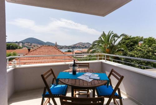 a dining room table with a balcony overlooking the ocean at Apartments Villa Karmen in Dubrovnik