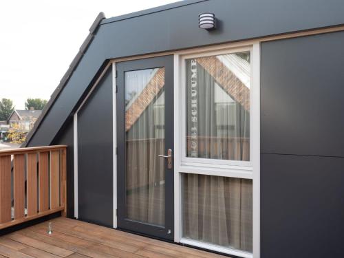 a house with sliding glass doors on a deck at Studio in Domburg near Beach and Golf in Renesse