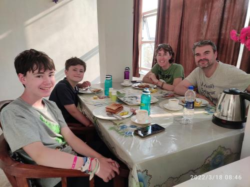 a group of young men sitting around a table at Max Guest House in Agra