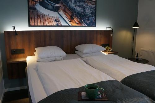 two beds in a hotel room with a tray on a table at Best Western Hotel Corallen in Oskarshamn