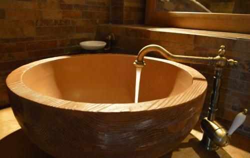 a large wooden tub with a faucet in a bathroom at Lithos Stone Suites in Areopolis