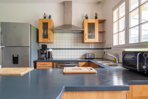 une cuisine avec un comptoir et un réfrigérateur dans l'établissement Grande maison familiale à 230m de la plage !, à Planguenoual